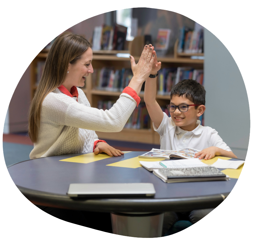 Student and Tutor high-fiving after getting a correct answer during a study session at the library
